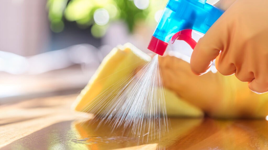 Cleaning with spray detergent, rubber gloves and dish cloth on work surface